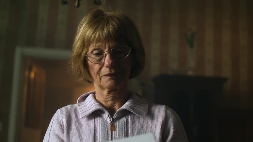 Middle aged woman stand in home examining box