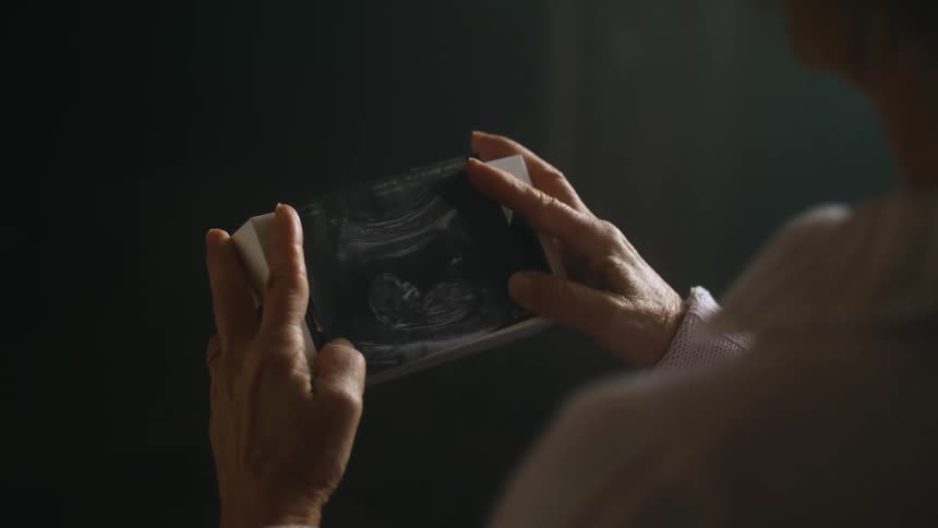 An elderly person is holding an electronic photo device