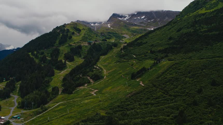 A mountain slope covered in vegetation under a cloudy daytime sky