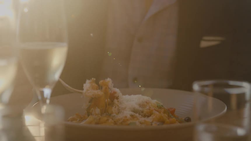 A man eats from a bowl while sitting outdoors during the day
