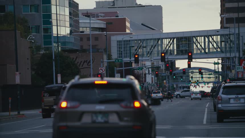Vehicles drive under pedestrian bridges that connect downtown buildings