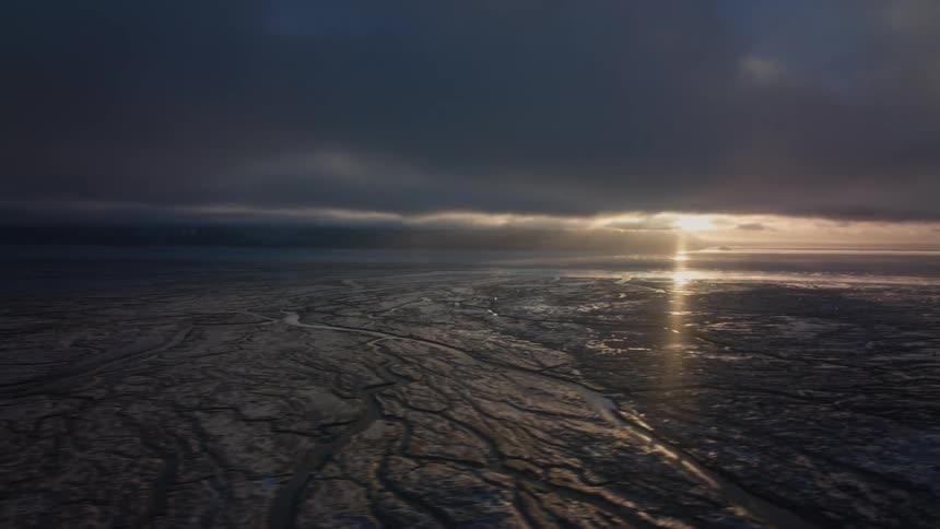 Ice clogs up the sea as the sun rises on a cloudy morning