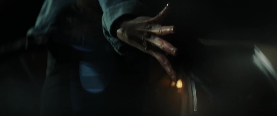 Womans arms reach back with splayed fingers as hair blows about her