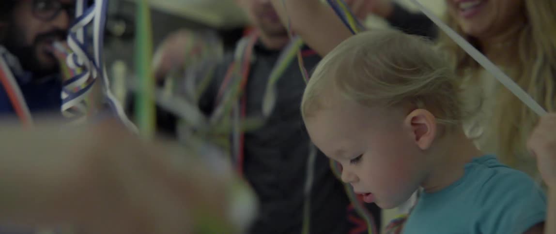 Joyful family and friends celebrating a special occasion with festive streamers in a home.