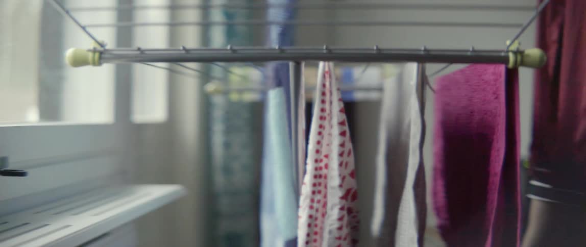 Freshly washed laundry hanging on an indoor clothesline during a routine household chore.