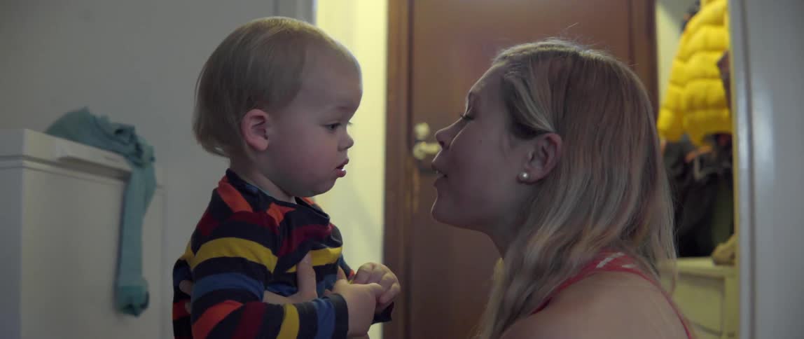 A woman shares a heartwarming moment while talking and interacting with her young toddler.