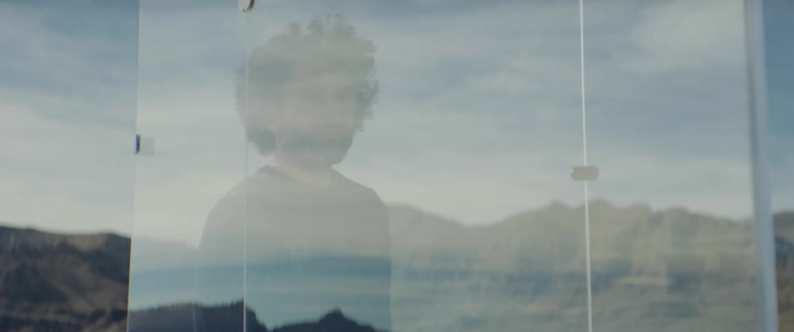 A man stands behind the glass and becomes transparent
