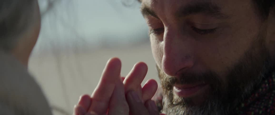 Woman comforts teary eyed man while standing together outdoors