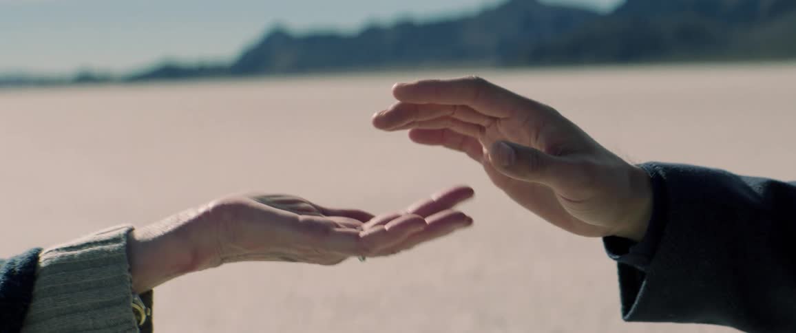 Close up of a man and woman touching fingers and then holding hands