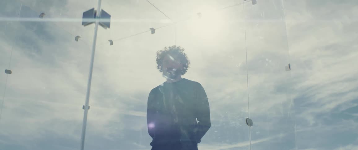 A man is trapped in a glass cell