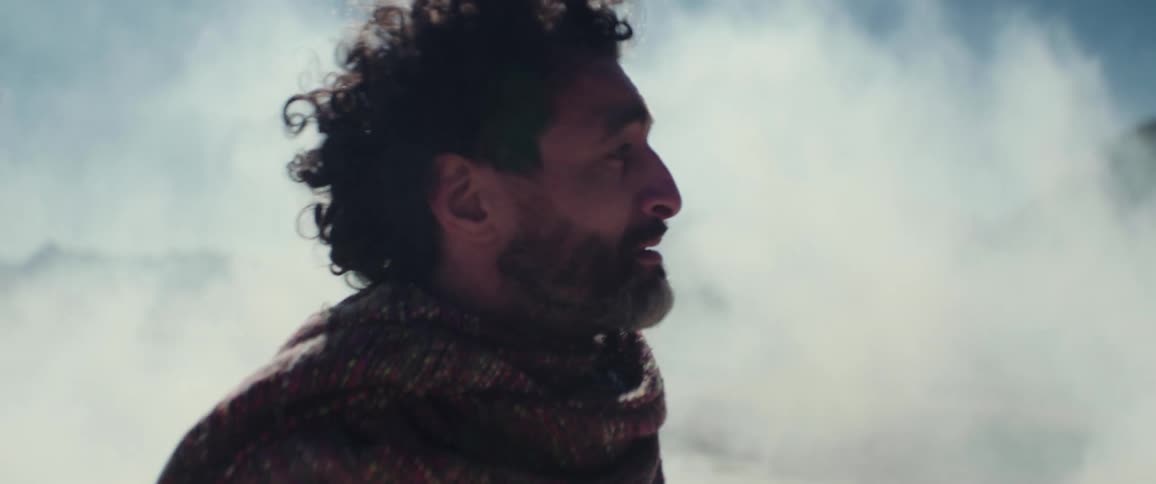 Distressed middle aged man standing in the middle of a fog cloud in a plain area looking for and asking for someone