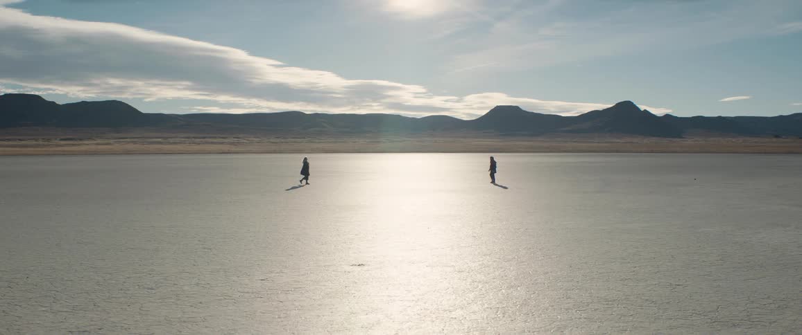 A man and woman walking toward each other outdoors