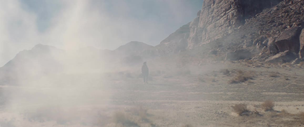 A person is walking near the mountain