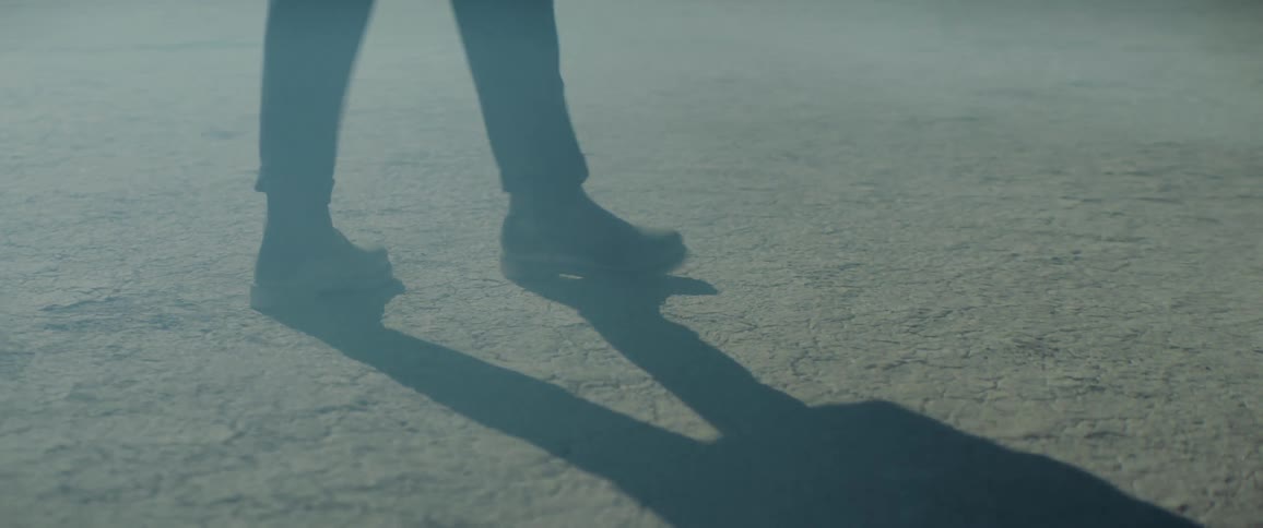 Close up of a persons feet as they walk and turn in circles in the desert