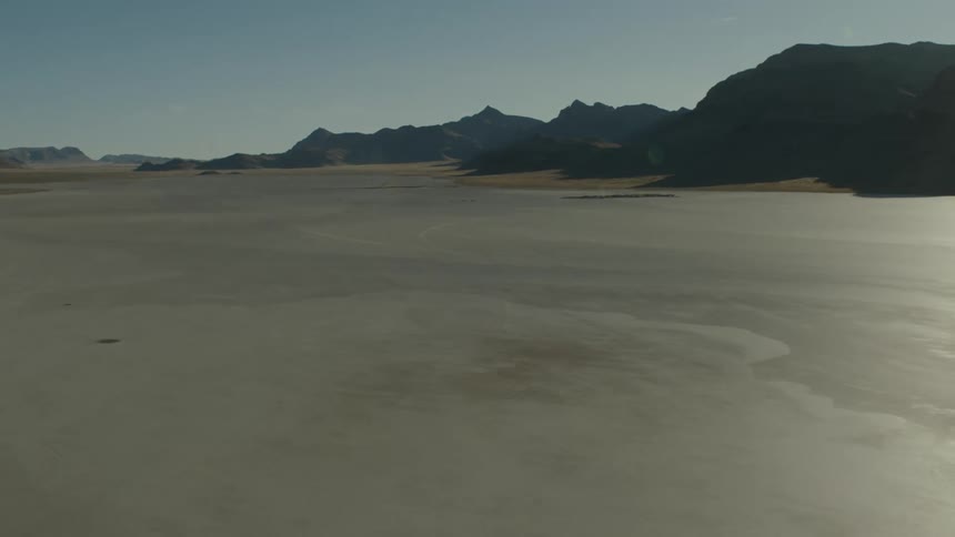 Desert with mountains and mountains in the distance under a clear sky