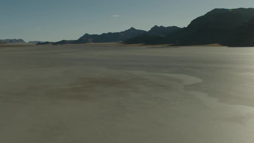 Desert with mountains and mountains in the distance under a clear sky