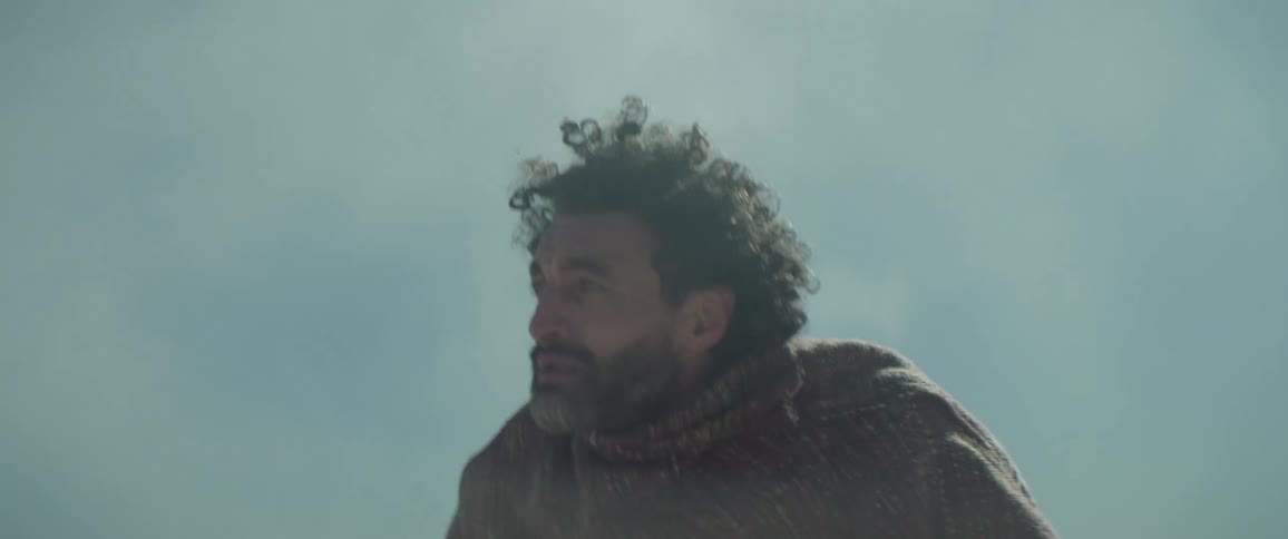 Kneeling man stands as fog blows across his figure obscuring it