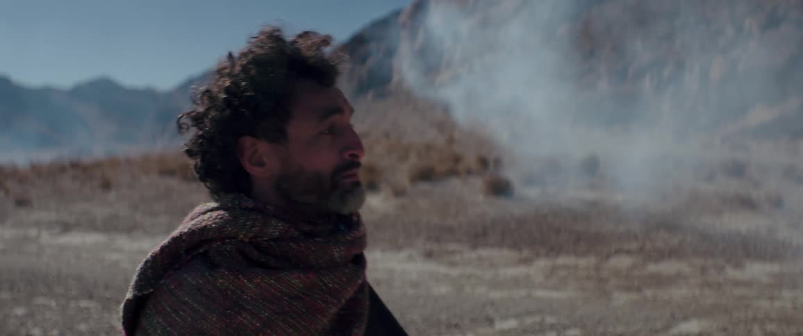 A man talks as he walks around a desert landscape