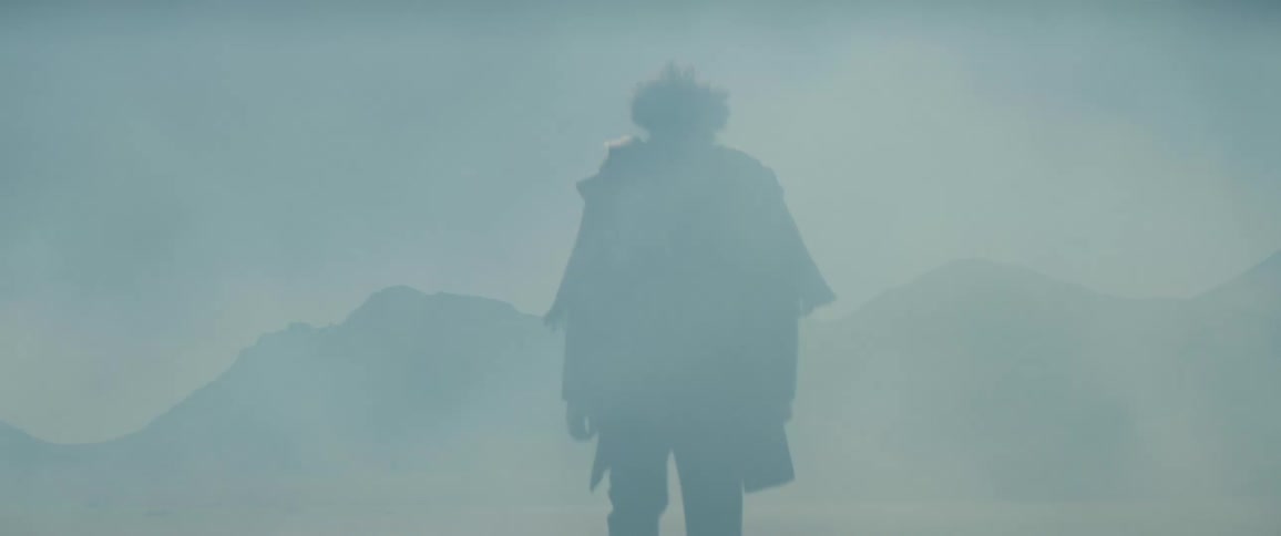 A man walks through a barren desert