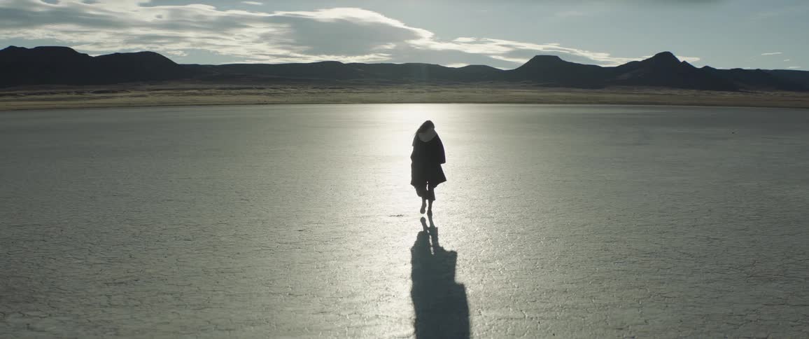 A woman walks out into the desert