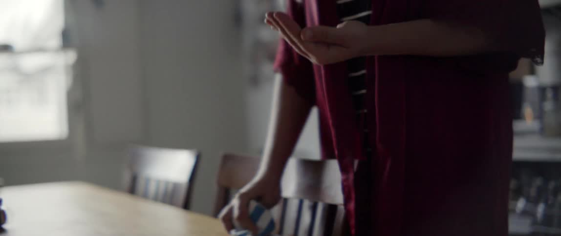 Young woman cleaning a wooden table surface during a routine household chore at home.