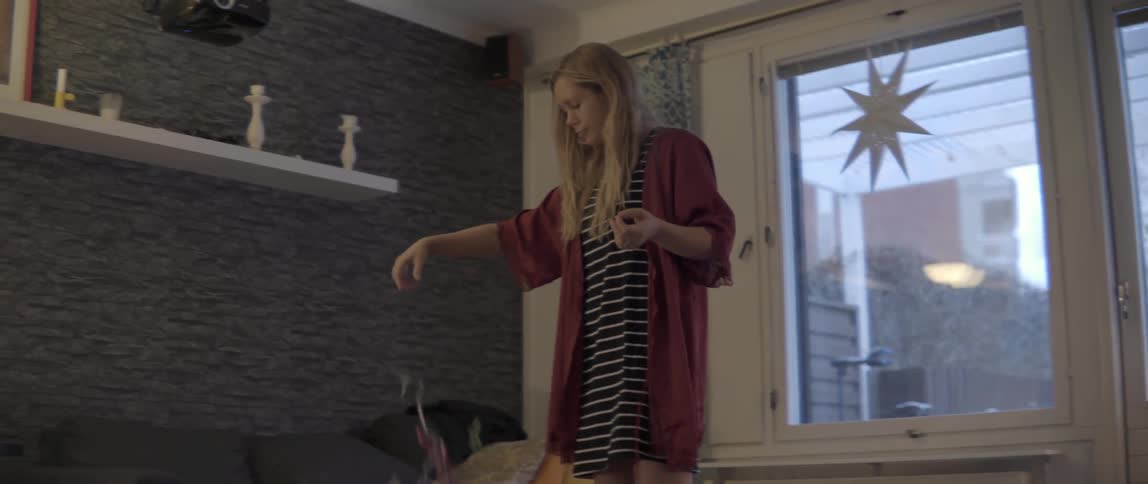 A woman cleans up confetti from off the floor of a living space