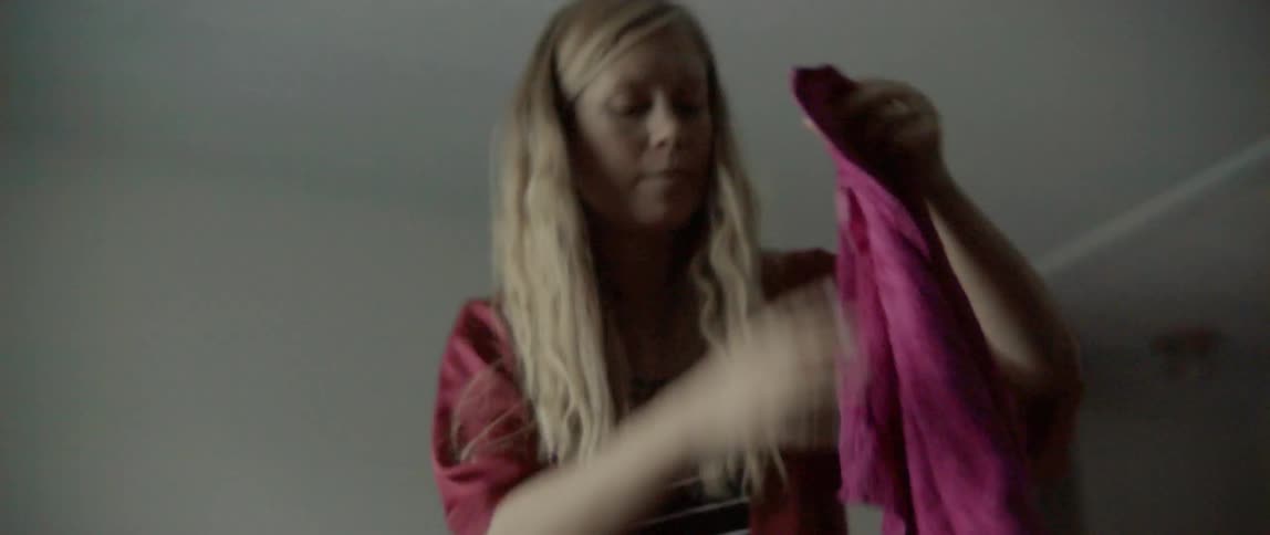 Woman setting up a rack and hanging wet clothes on it