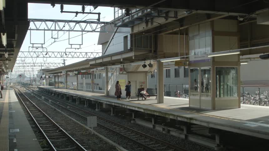 Two woman stopping and talking next to railroad tracks