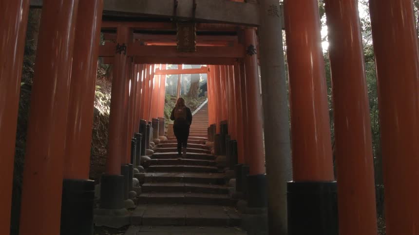 A woman ascending covered, outdoor stairs