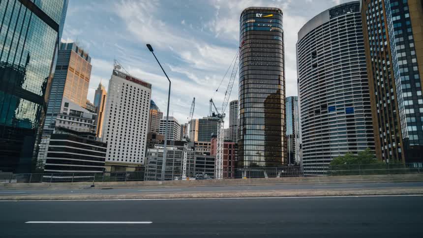 Traffic travels along a road through a metropolis throughout the day and night