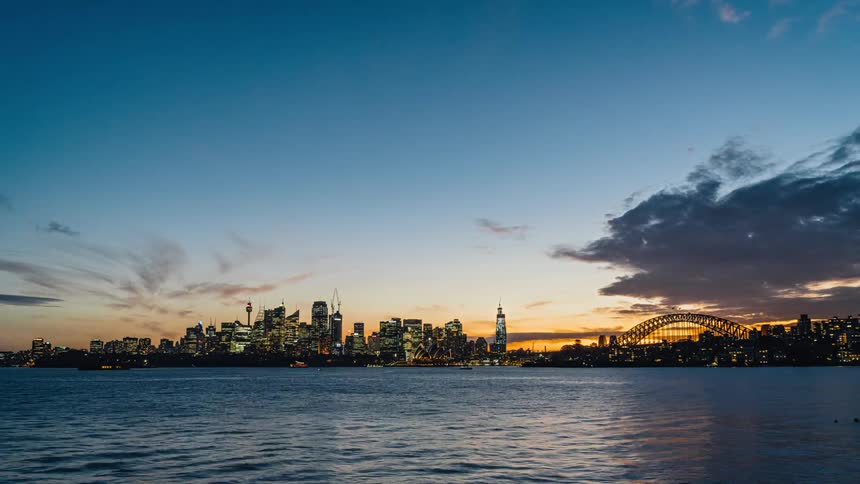 Time lapse of skyline across the harbor from day to night