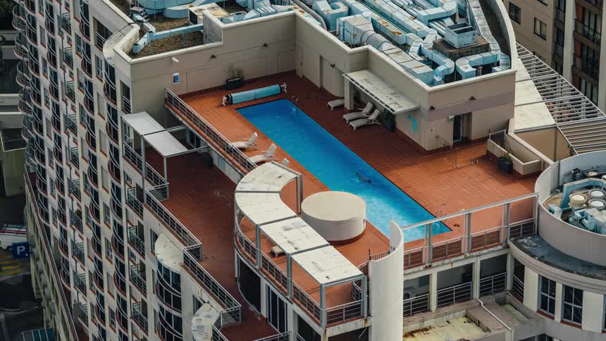 A man swimming laps in a roof top pool
