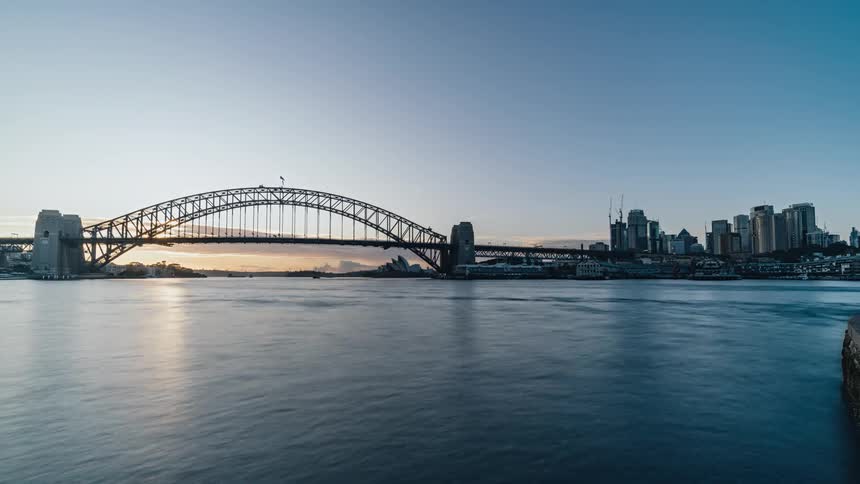 Time lapse view of ocean water near a downtown city is displayed