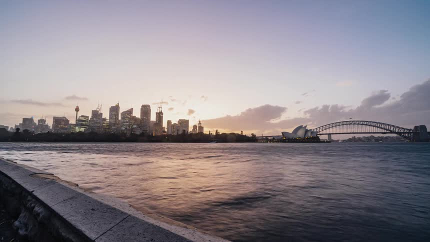 Time lapse view of a city near an ocean is displayed