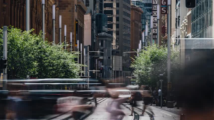 Time lapse view of pedestrians and cars moving through a city