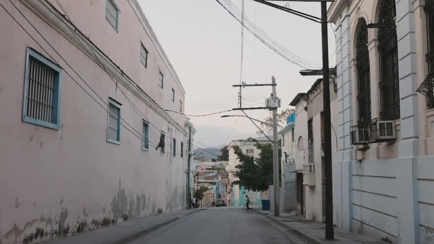 Pedestrians cross street in the backstreets of Cuba