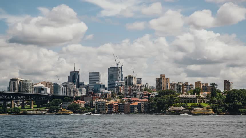 Time lapse view of people boating on a lake near a downtown city