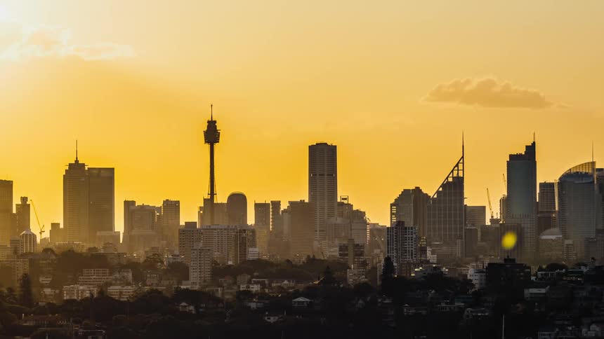 Clouds floating above tall skyscrapers at sunset