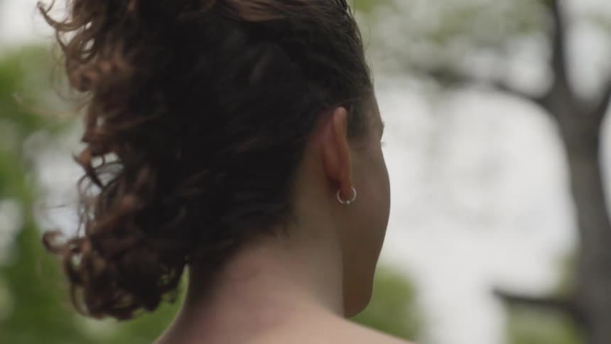 A woman is standing outdoors during the spring time
