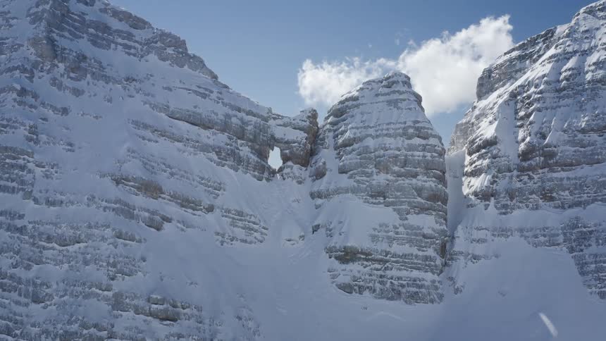 An aerial view of snow covered mountains in nature on a winter day