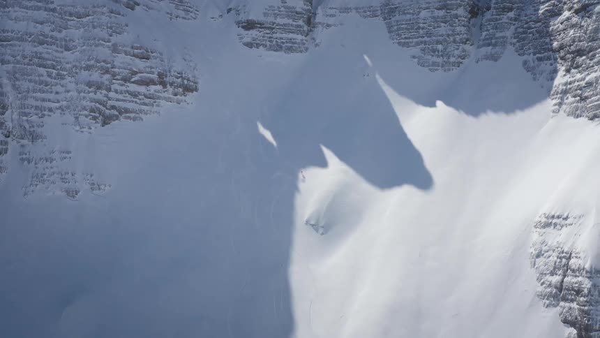 Thick snow and ice covers steep cliffs of mountains