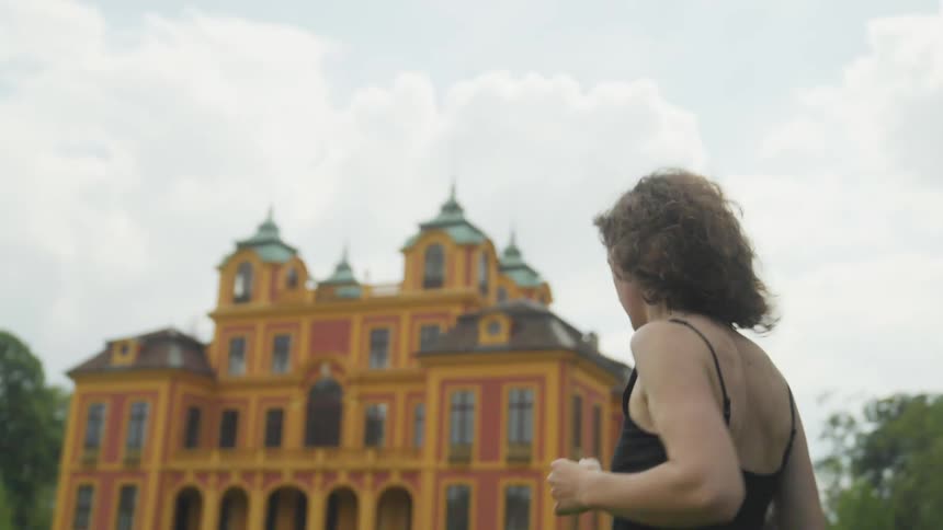 A person is jogging outdoors in front of a building