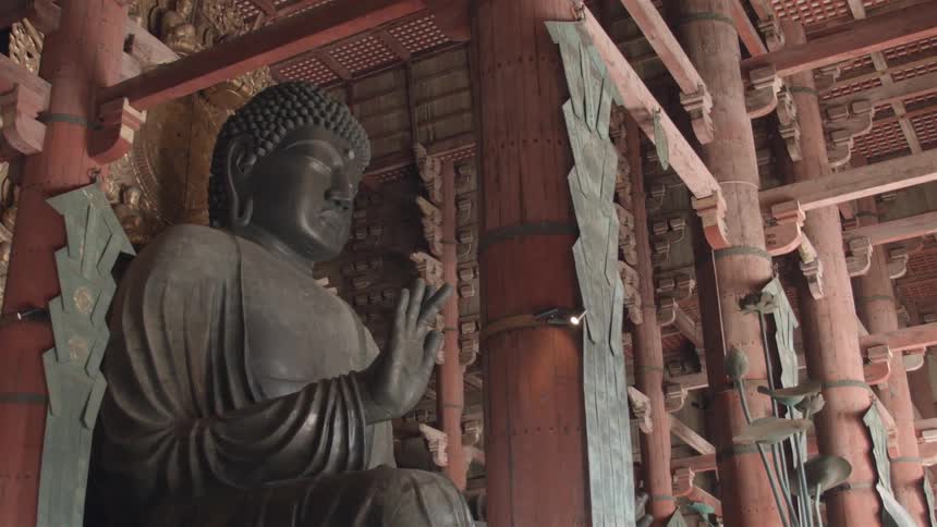A large metal statue sits near wooden pillars
