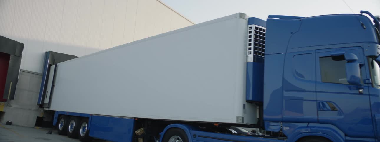 A truck is parked at a shipping station during day time