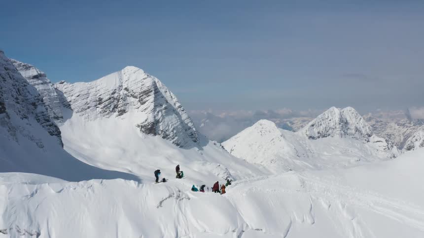 An aerial view of people with skis and snowboards on a mountain range