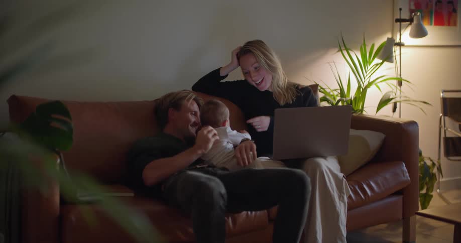 A family is sitting on the sofa and hanging out together