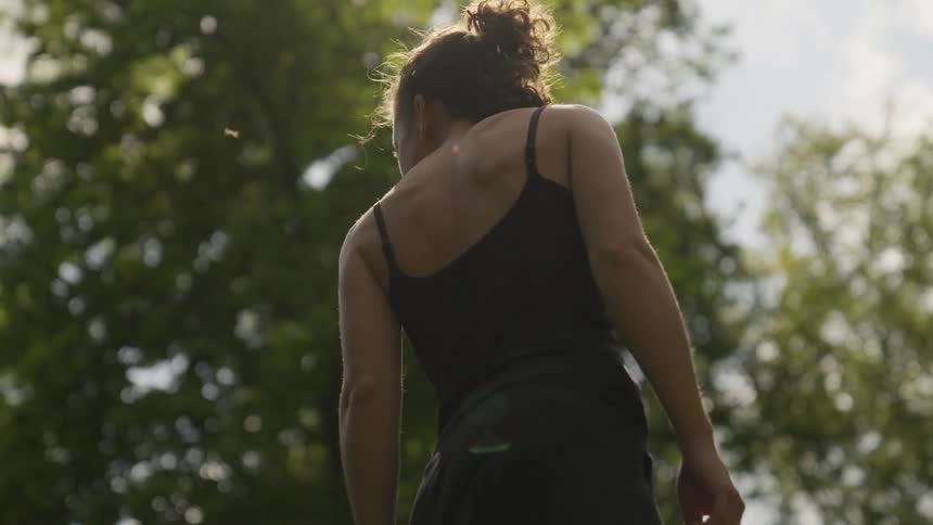A woman is standing outdoors during the spring time