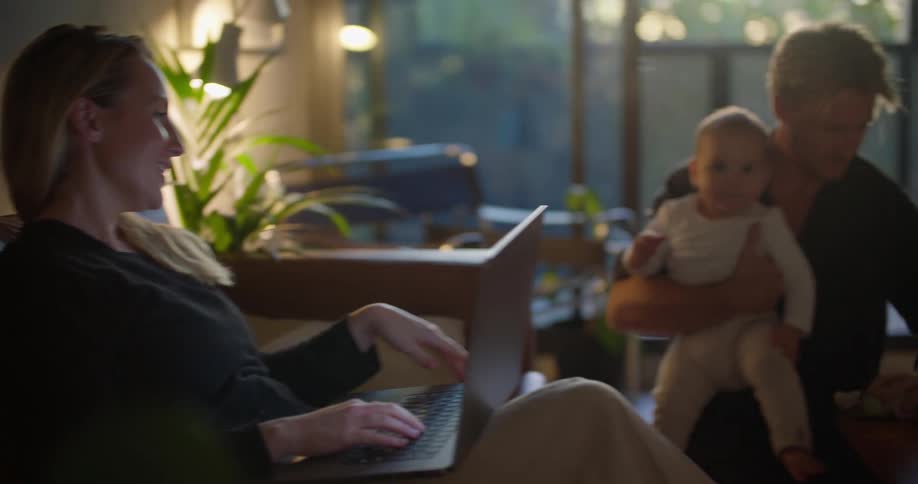 A mother is on her laptop and hanging out with her family