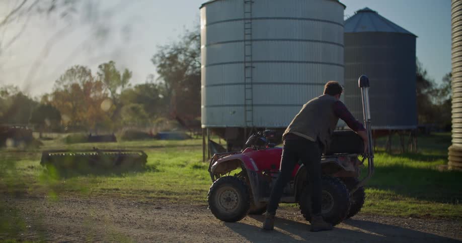 A man is driving a tractor on his farm land