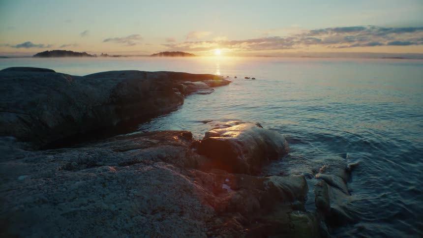 The sun is setting in the horizon of an ocean